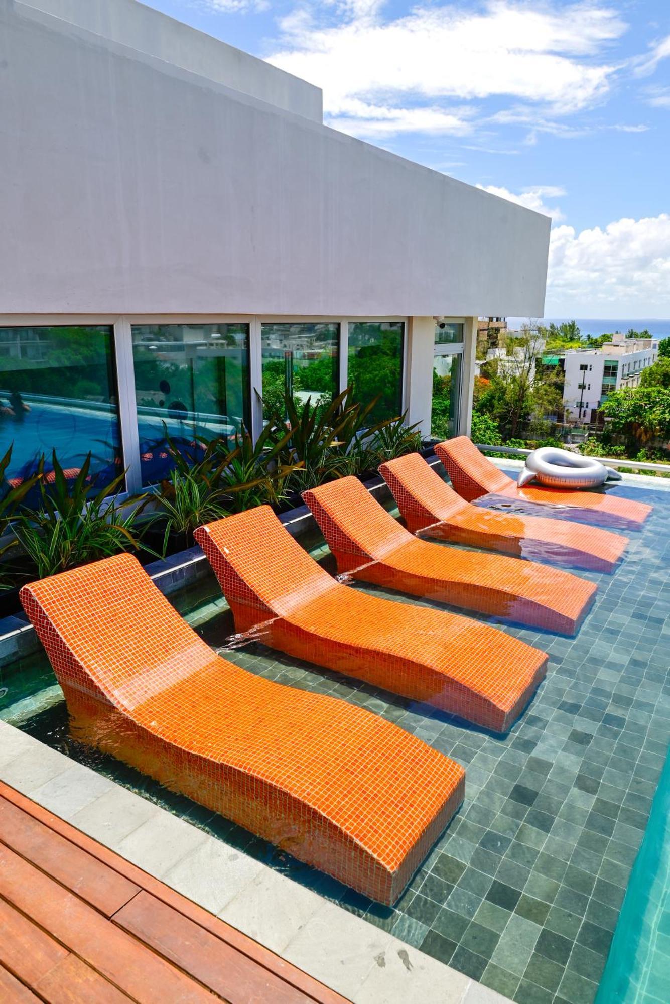 Hotel Aloft Playa Del Carmen Exterior foto Sunbathing chairs at a pool